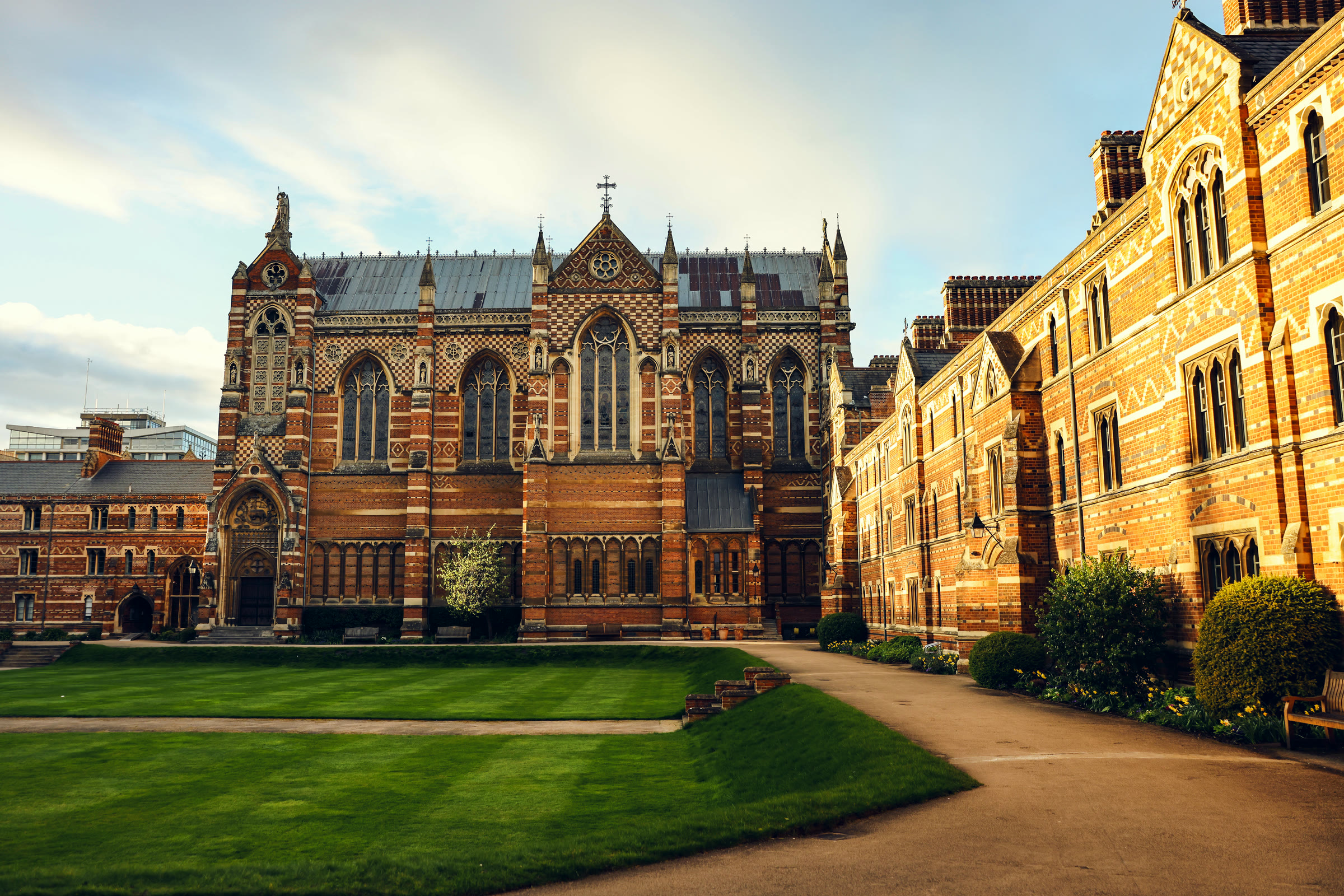 The main quadrangle of Keble College, Oxford, its warm red-brick Victorian facades and chapel tower rising above a wide green lawn